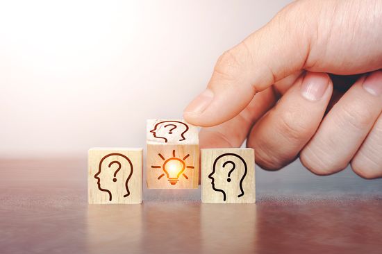 Hand dreht Würfel um mit Idee-Symbol